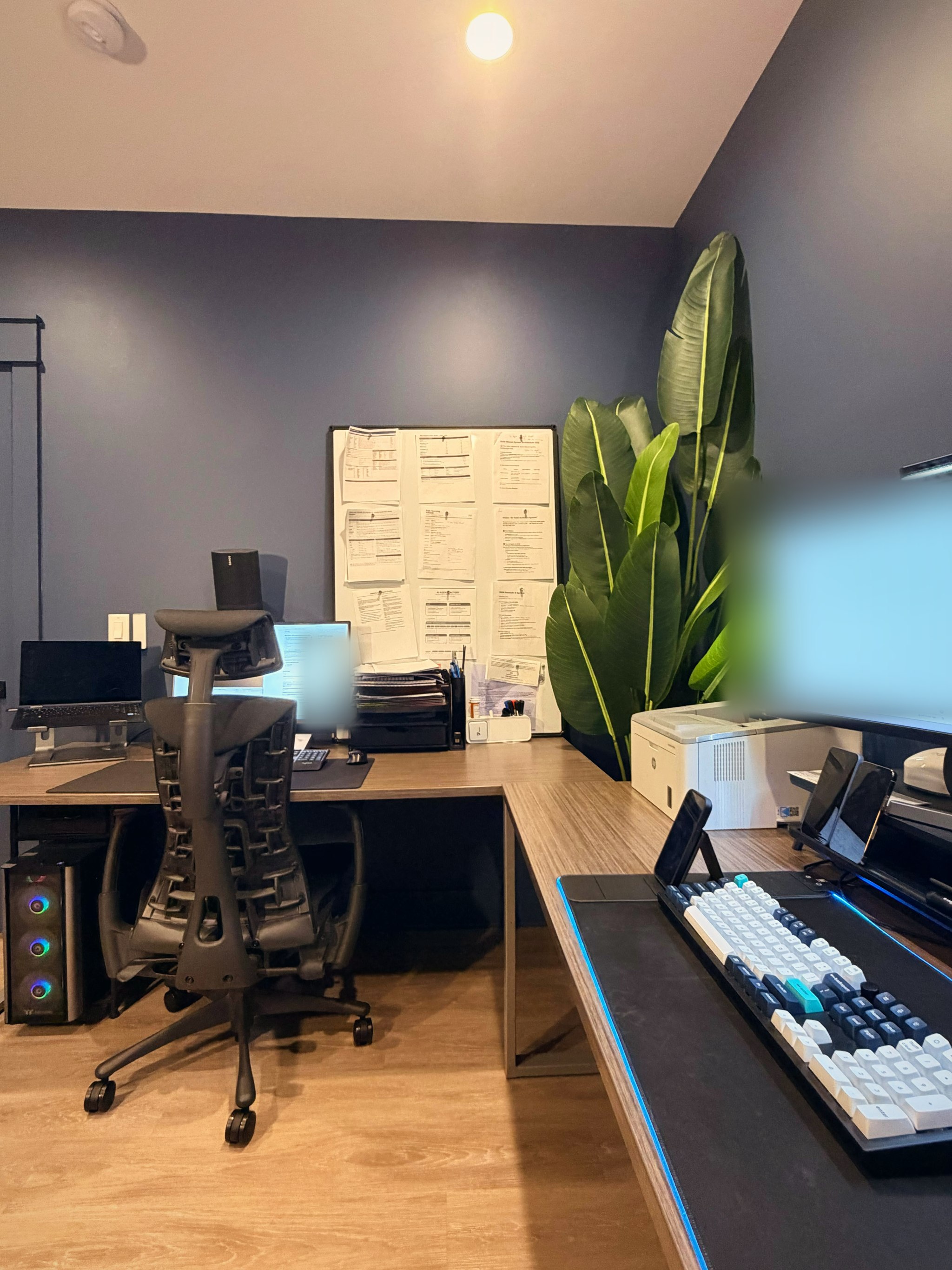 The AI PC wing: single monitor, document board and chair, screen blurred